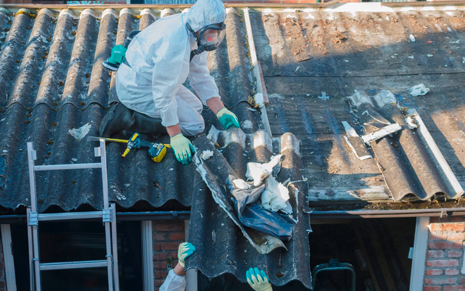 Arbeiter, die einen Sicherheitsanzug anhaben und Dacharbeiten durchführen