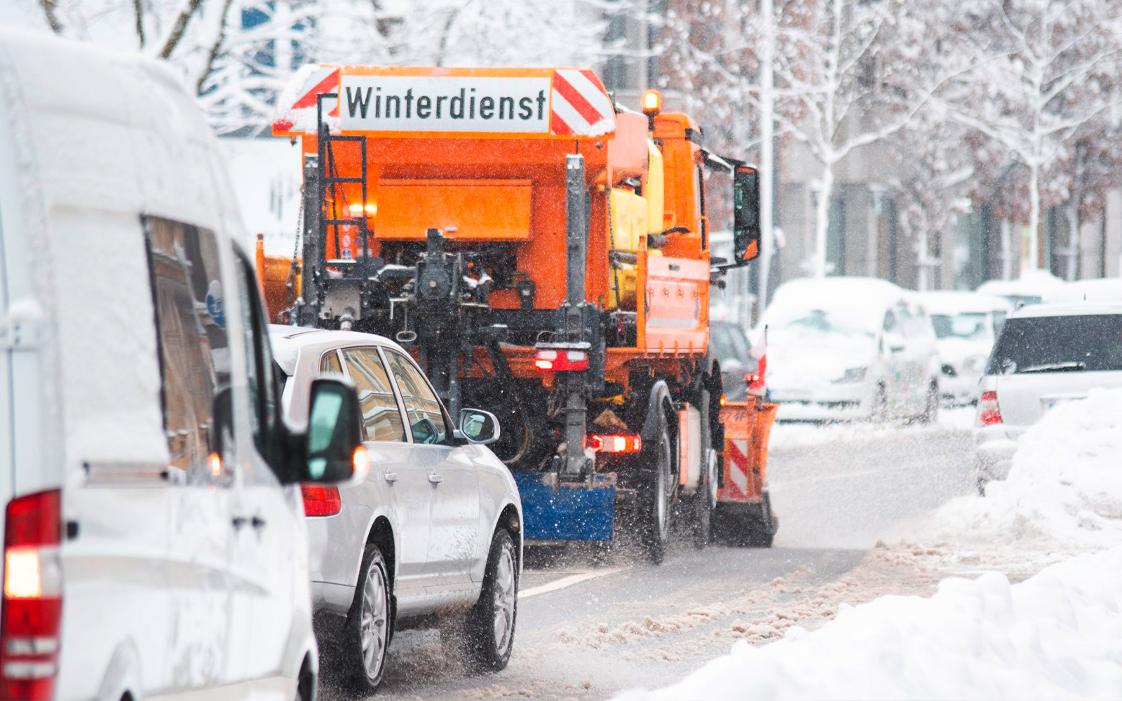 Ein Winterdienstauto räumt eine schneebedeckte Straße